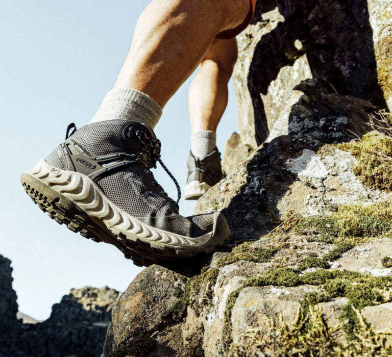 Hiker wearing hiking shoes while walking on a rocky mountain trail
